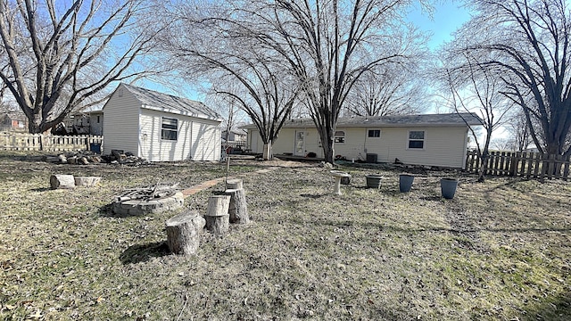 view of yard with a shed, a fire pit, an outdoor structure, and fence