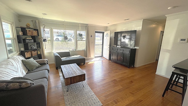 living room with baseboards, wood finished floors, and ornamental molding