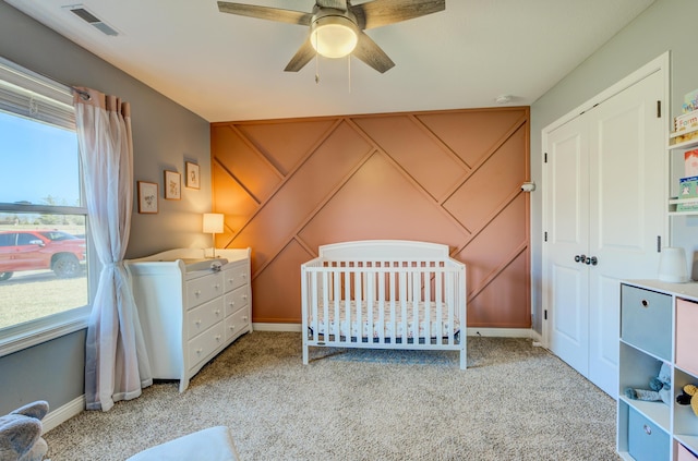 unfurnished bedroom with visible vents, carpet floors, a nursery area, and a closet