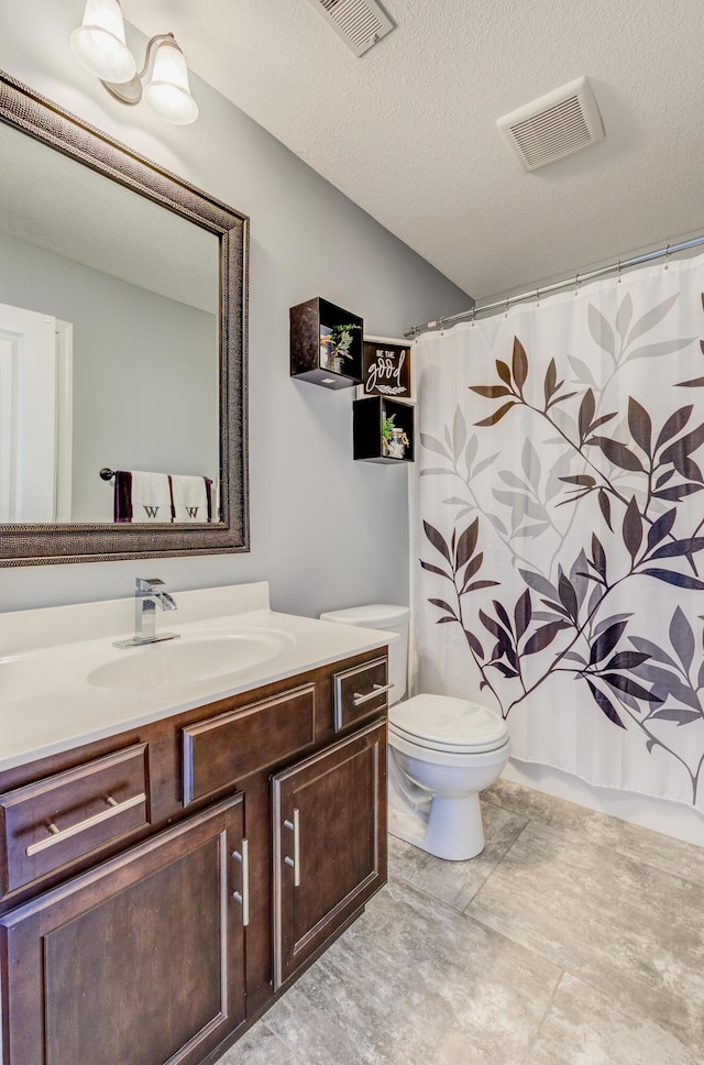 bathroom with visible vents, toilet, a textured ceiling, and vanity