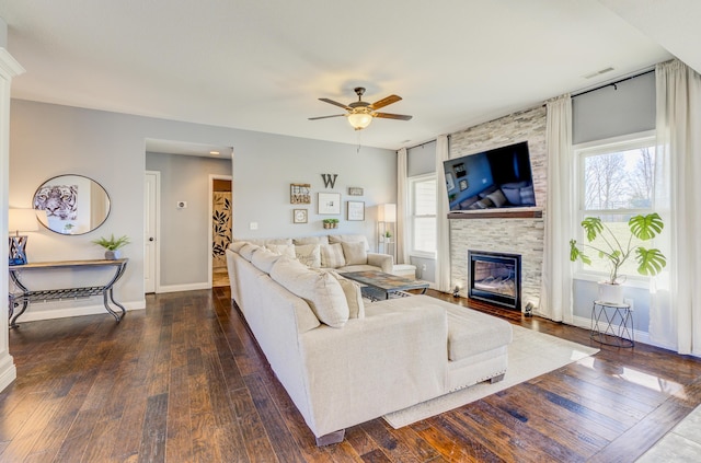 living room featuring a wealth of natural light, a large fireplace, a ceiling fan, and hardwood / wood-style floors