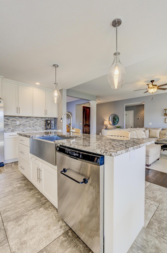 kitchen featuring open floor plan, backsplash, white cabinetry, and stainless steel appliances