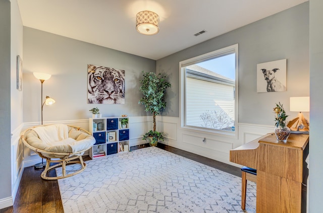 sitting room featuring visible vents, a wainscoted wall, and wood finished floors