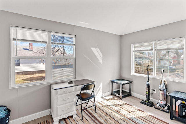 home office featuring baseboards, a healthy amount of sunlight, and light wood finished floors