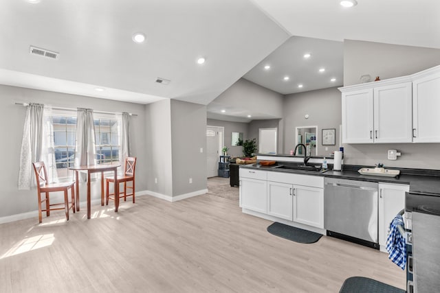 kitchen featuring a sink, visible vents, stainless steel dishwasher, and dark countertops