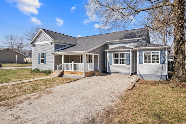 view of front of home with a porch, a shingled roof, driveway, and a front lawn