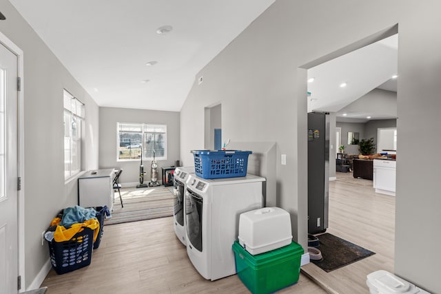 laundry room with washer and dryer, light wood-type flooring, baseboards, and laundry area