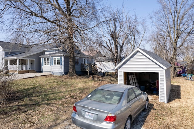 exterior space with a porch, an outdoor structure, and a garage