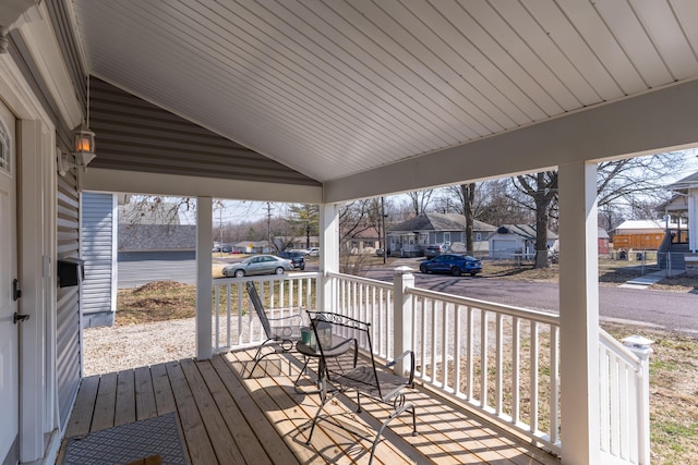 wooden terrace featuring covered porch and a residential view