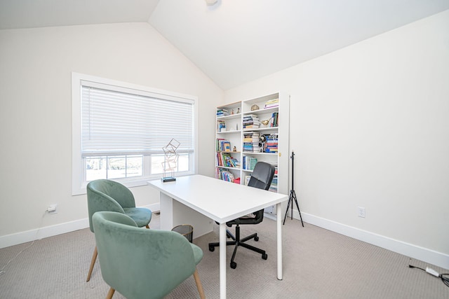 home office with lofted ceiling, baseboards, and light carpet