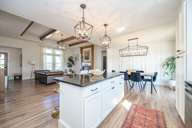 kitchen with light wood-style flooring, beamed ceiling, white cabinets, and a chandelier