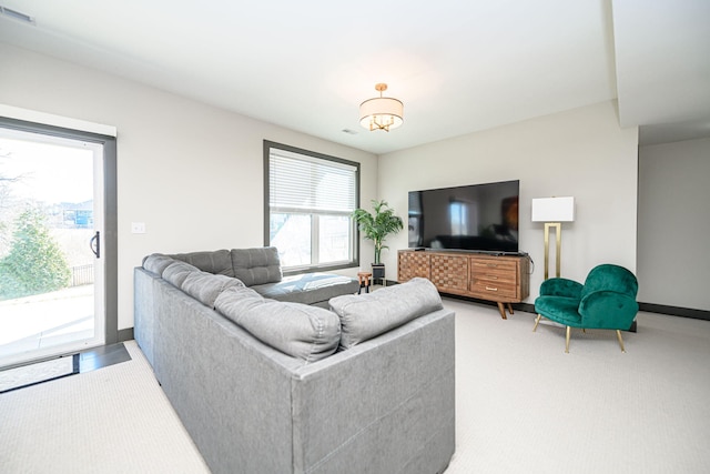 living room with baseboards, visible vents, and light carpet