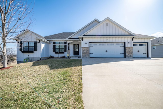 view of front facade featuring concrete driveway, a front lawn, a garage, stone siding, and board and batten siding