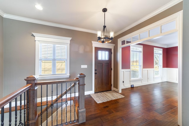 entrance foyer featuring a notable chandelier, crown molding, and hardwood / wood-style flooring