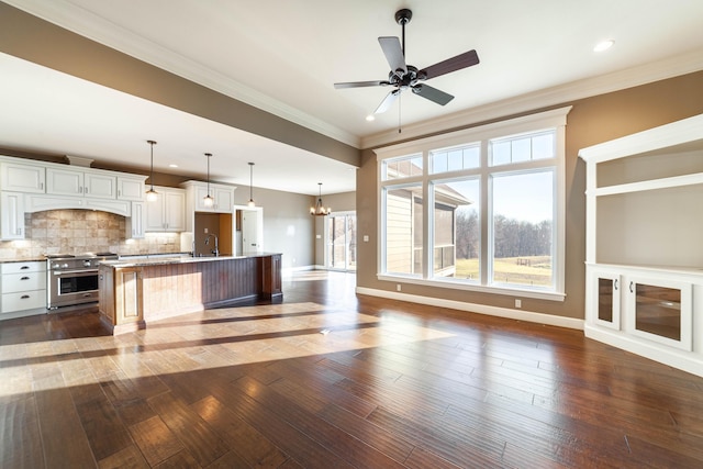 kitchen featuring high end range, ornamental molding, dark wood-type flooring, and a sink