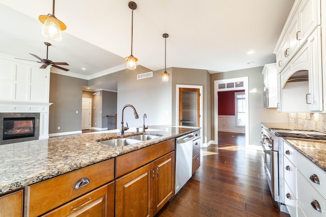 kitchen featuring a ceiling fan, brown cabinetry, visible vents, a sink, and appliances with stainless steel finishes