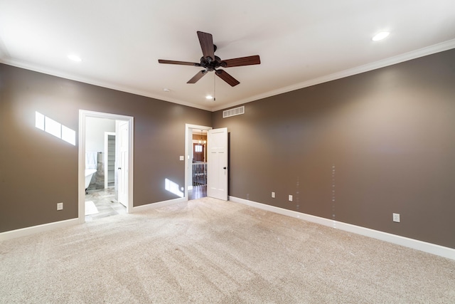 empty room featuring visible vents, a ceiling fan, crown molding, baseboards, and light colored carpet