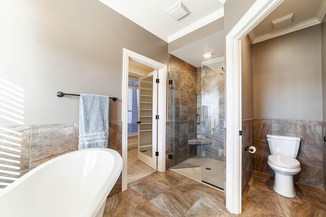 full bath featuring a shower stall, tile walls, toilet, and a freestanding tub