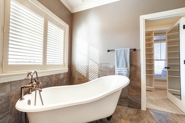 bathroom featuring tile walls, crown molding, a wainscoted wall, and a freestanding bath