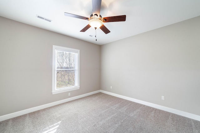 unfurnished room featuring visible vents, carpet floors, baseboards, and a ceiling fan