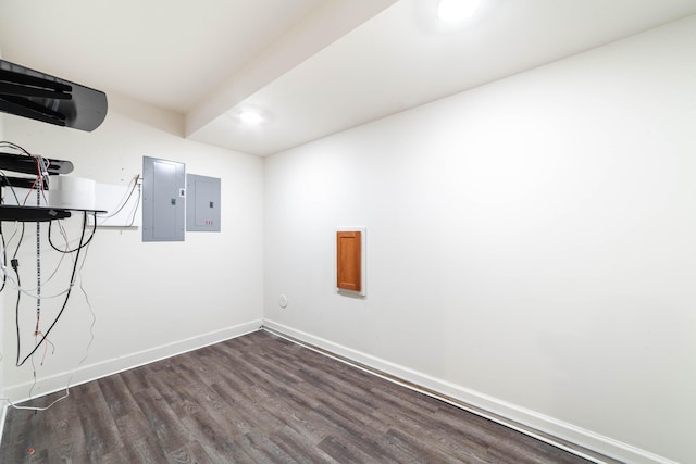 unfurnished room featuring dark wood-type flooring, electric panel, and baseboards