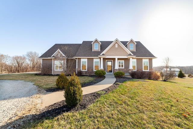 craftsman house with stone siding and a front lawn