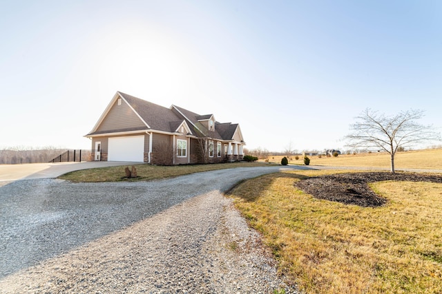 view of front of property with brick siding, an attached garage, driveway, and fence