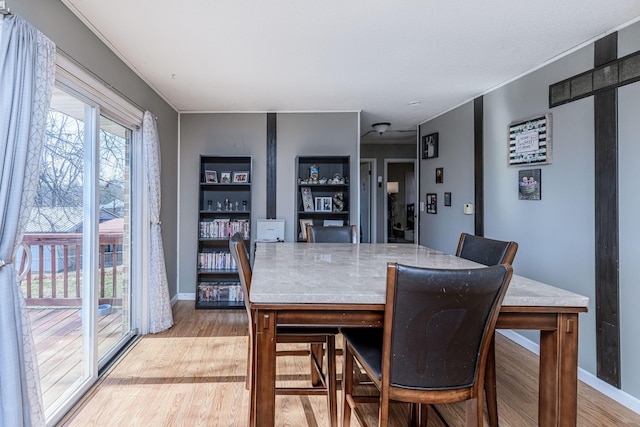 dining room featuring baseboards and light wood-type flooring