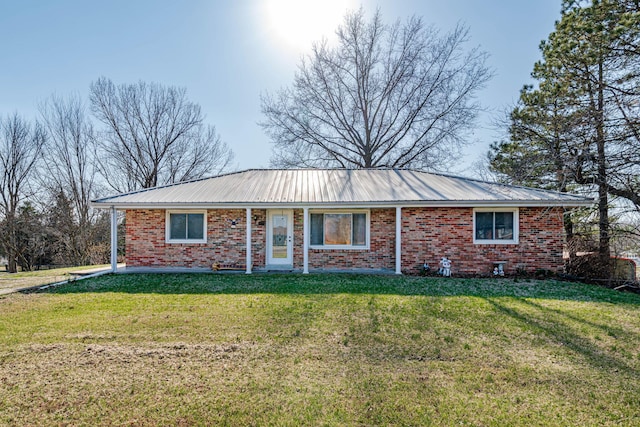 ranch-style home with a front lawn, brick siding, and metal roof