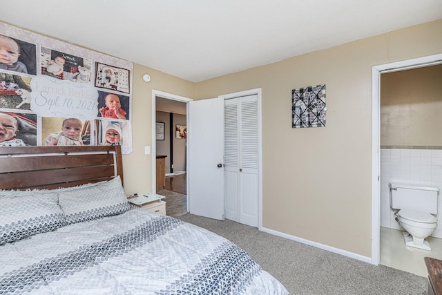 bedroom featuring a closet, carpet flooring, tile walls, and ensuite bath