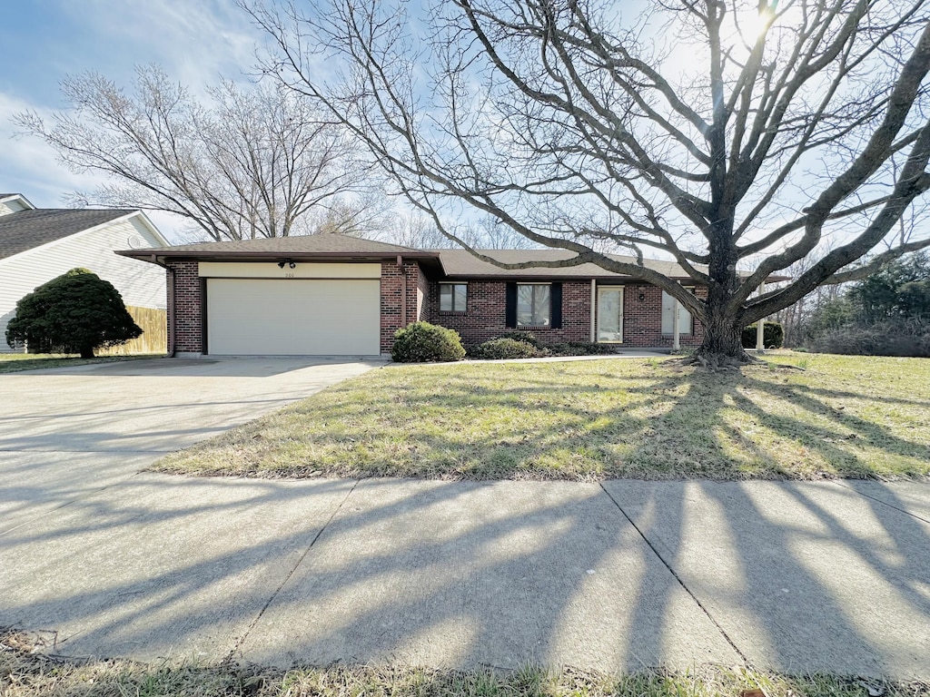 single story home featuring concrete driveway, brick siding, a garage, and a front lawn