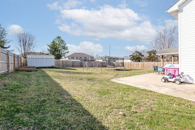 view of yard featuring an outdoor structure, a trampoline, a fenced backyard, and a patio area