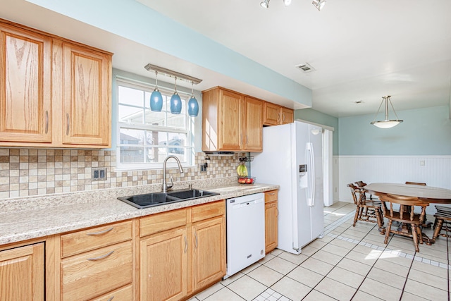 kitchen with visible vents, a wainscoted wall, a sink, white appliances, and light tile patterned floors