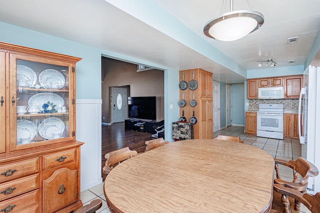 dining space with light tile patterned floors and visible vents