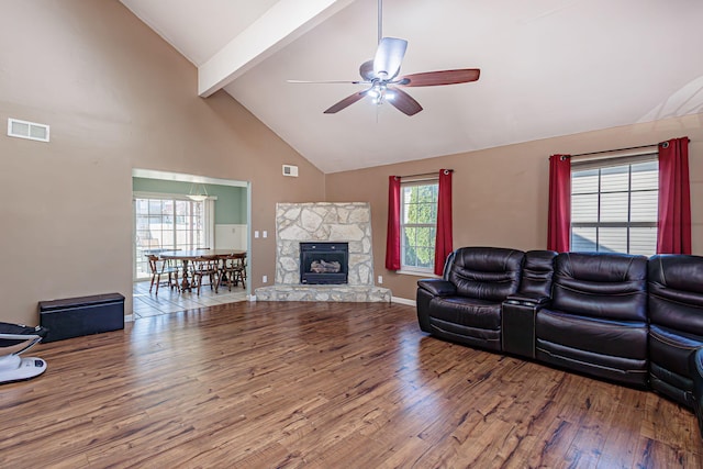 living area featuring wood finished floors, visible vents, high vaulted ceiling, ceiling fan, and beamed ceiling