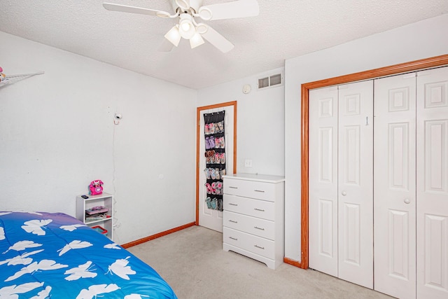 unfurnished bedroom with visible vents, light carpet, a textured ceiling, and a closet