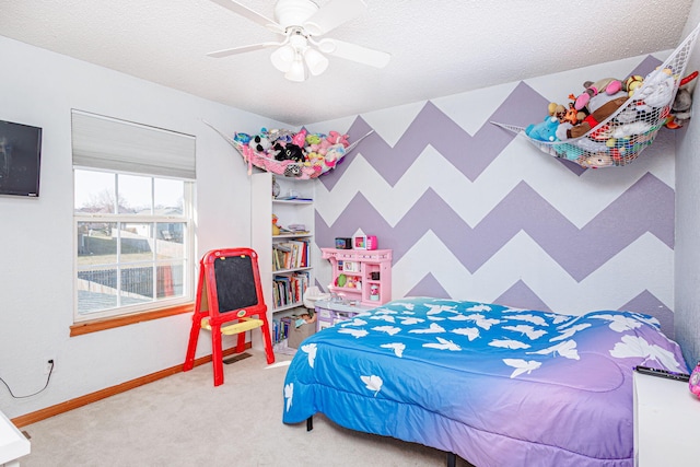 bedroom with baseboards, carpet floors, ceiling fan, a textured ceiling, and an accent wall