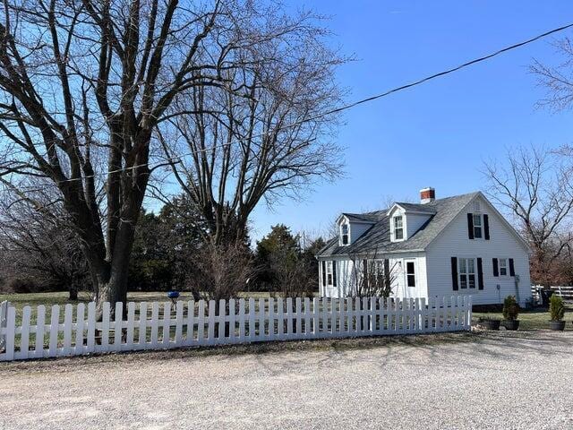 view of front of home with a fenced front yard and a chimney