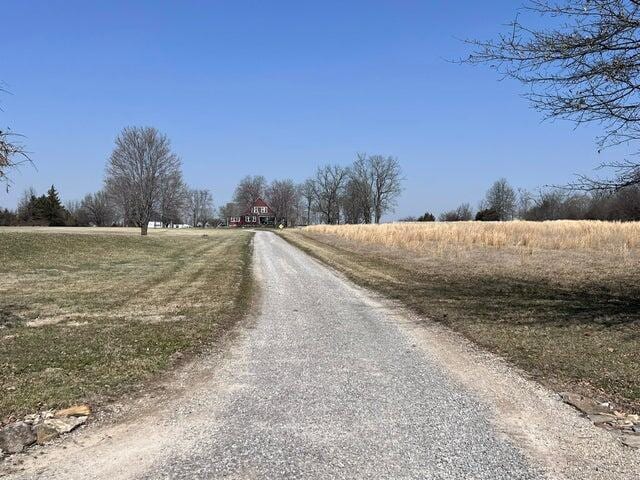 view of street featuring a rural view and gravel driveway