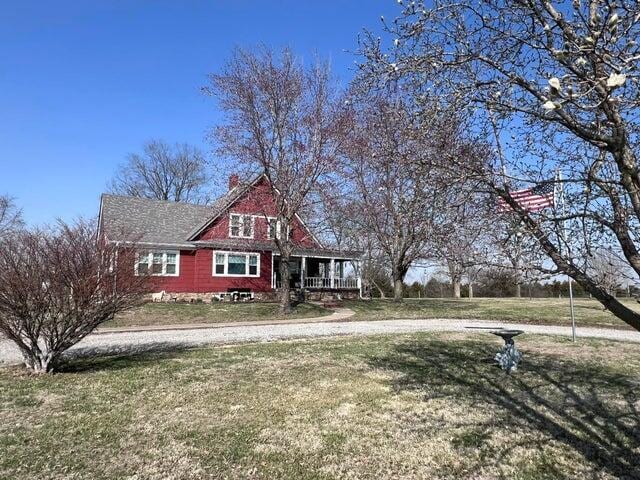 view of front of house with covered porch and a front lawn