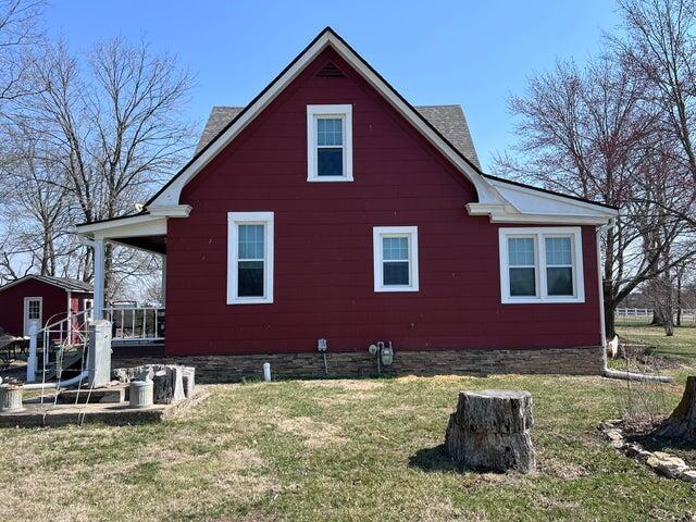 view of side of home featuring an outbuilding and a lawn