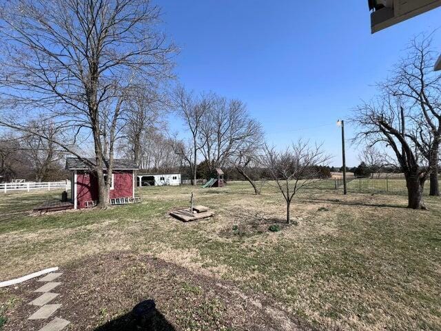 view of yard with an outdoor structure and fence