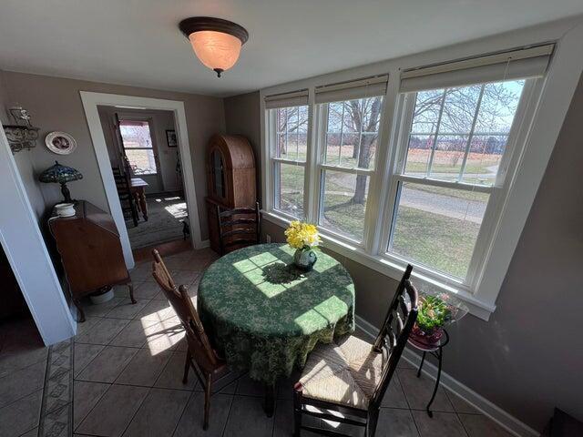 dining space featuring light tile patterned floors and baseboards