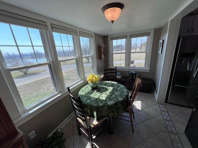 dining room featuring light tile patterned floors, plenty of natural light, and baseboards