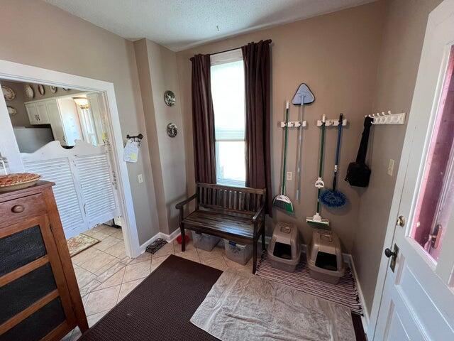 bathroom with tile patterned floors, baseboards, and a textured ceiling