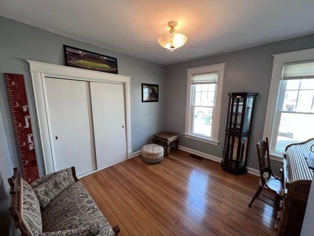 sitting room with a healthy amount of sunlight, baseboards, and hardwood / wood-style floors