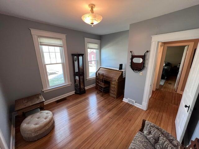 interior space featuring hardwood / wood-style flooring, baseboards, and visible vents