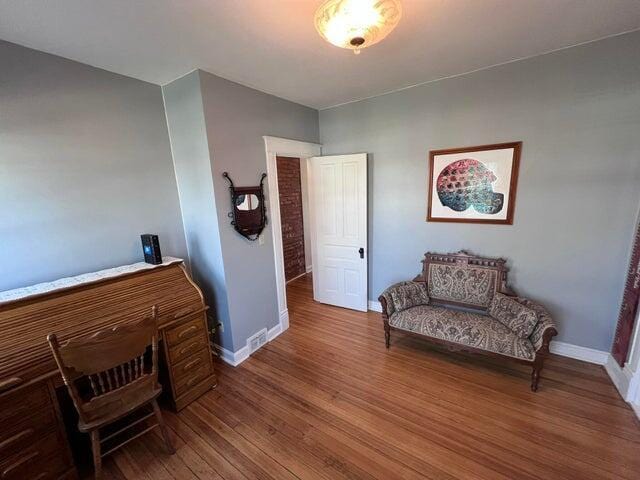 sitting room with baseboards and wood finished floors