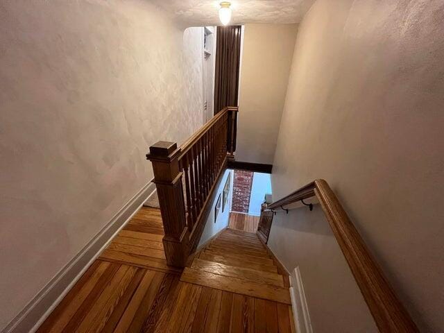 staircase with baseboards and hardwood / wood-style flooring