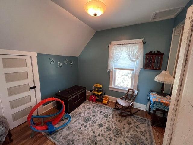 game room featuring attic access, baseboards, lofted ceiling, and wood finished floors